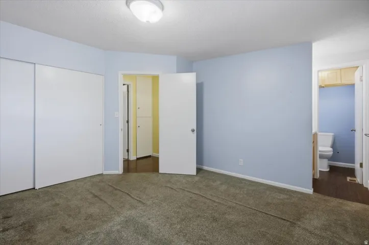 Wall-to-wall carpeting with light blue wall paint and white baseboards