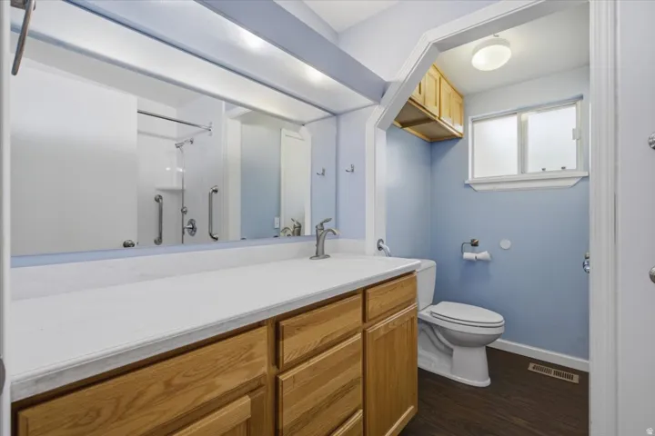 Vanity with a white countertop and wood-finish cabinetry
