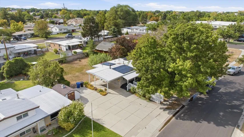 Single-story residential property featuring a carport, solar panels, and a concrete driveway