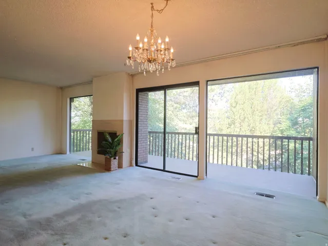Room featuring a crystal chandelier, built-in fireplace, and expansive glass sliding doors
