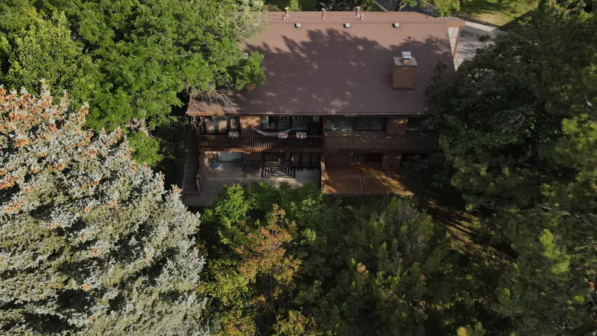 Aerial view showcasing this residence nestled within mature landscaping and established trees