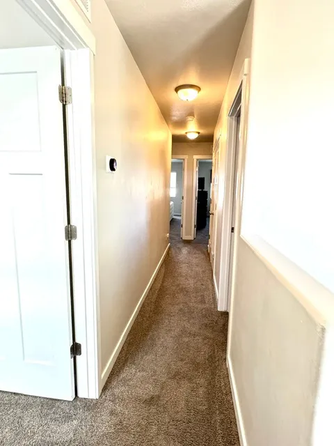 Hallway leading to laundry room, bathroom, bedroom #2 and primary  bedroom