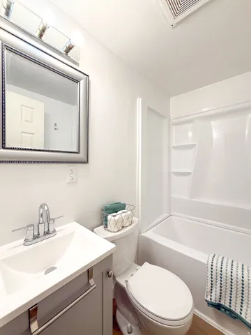 Bathroom with a single vanity, undermount sink, chrome faucet, and a combined shower and bathtub
