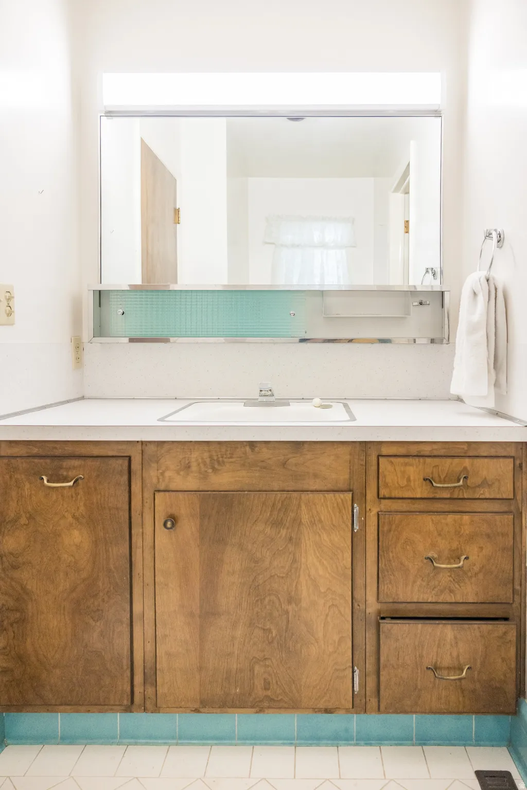 Wood-finish vanity with an integrated sink and white countertop