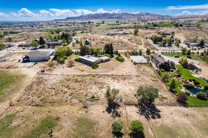 Expansive property featuring undeveloped land, established trees, and mountainous terrain in the background