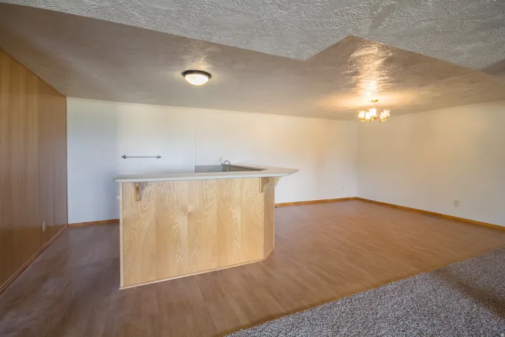 Built-in wet bar with a light wood finish, integrated sink, and light-toned countertop