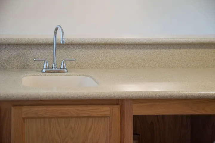 Integrated sink with a chrome faucet, set into a speckled countertop