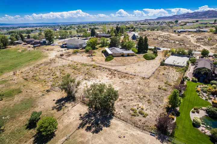 Expansive property featuring a large undeveloped parcel, a manicured lawn area, and established landscaping