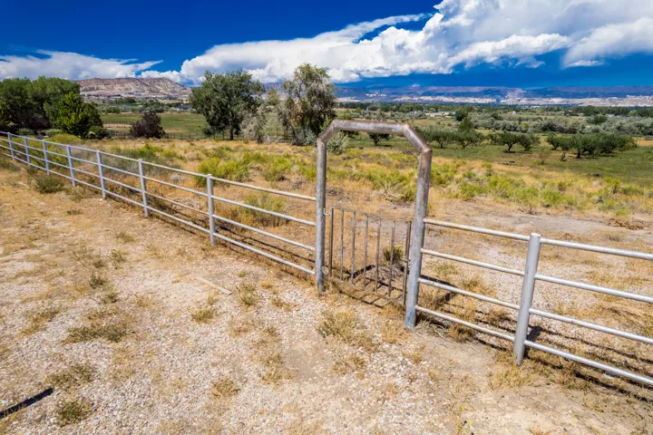 Fenced perimeter with a metal gate and expansive open space