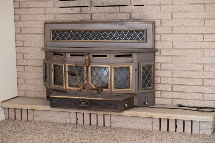 Brick-faced fireplace with a metal insert and a stone hearth