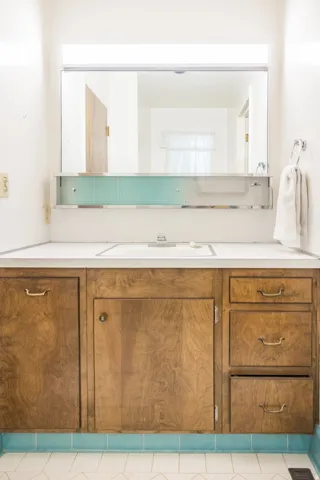 Wood-finish vanity with an integrated sink and white countertop