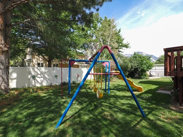 Expansive green lawn with mature trees and privacy fencing