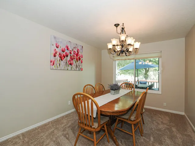 Recessed window overlooking a private deck, overhead chandelier, and neutral wall color