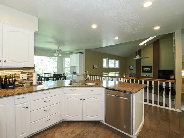 Kitchen with white cabinetry, speckled countertops, and a mosaic tile backsplash