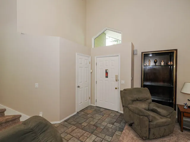 Vaulted ceiling, transom window, tile flooring, paneled interior doors, and built-in shelving