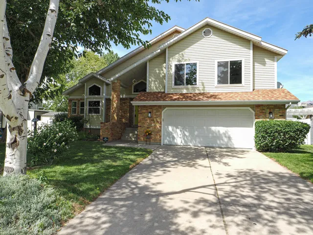 Two-story exterior with vinyl siding and brick accents, an attached two-car garage, and a concrete driveway