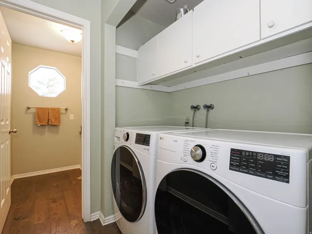 Dedicated laundry area featuring upper white cabinetry, a built-in shelf, and plumbing hookups