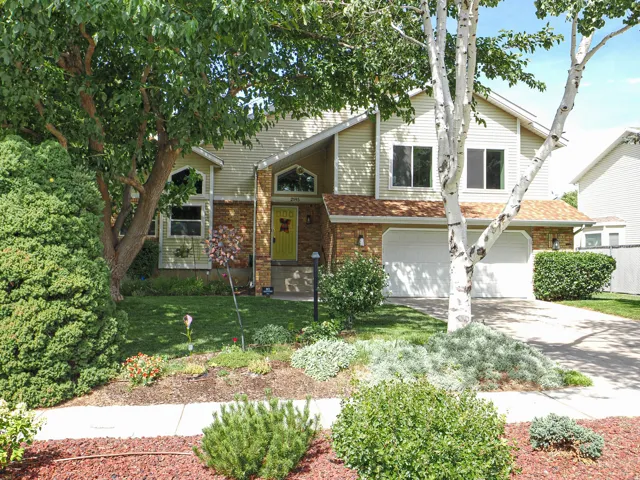 Two-story residence featuring light-colored siding, brick accents, and a two-car garage