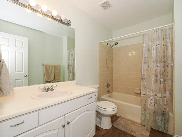 Bathroom featuring a vanity with an integrated sink, polished chrome faucet, full-width mirror, and a tiled tub and shower combination