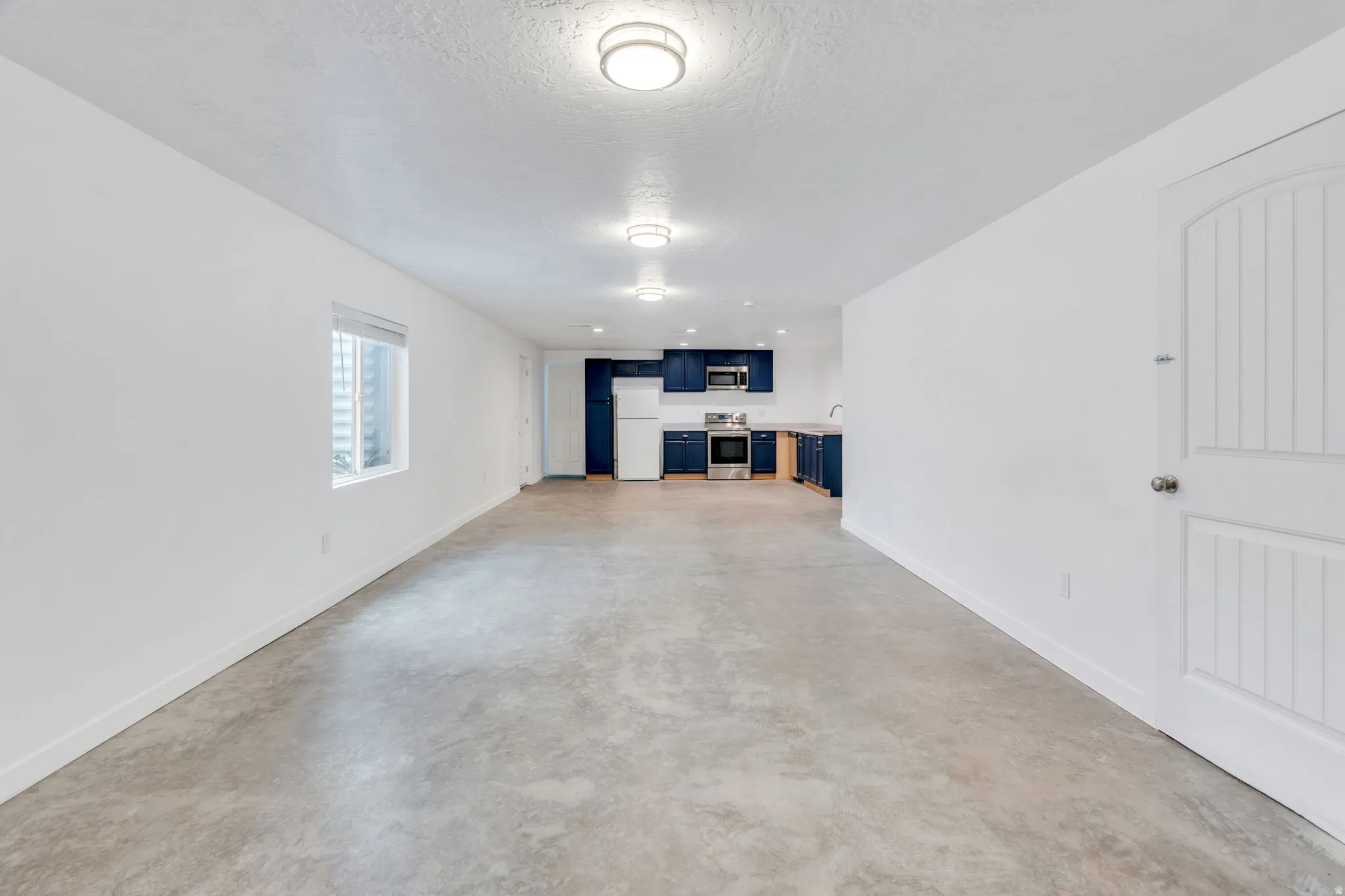 Open-concept living space with concrete flooring