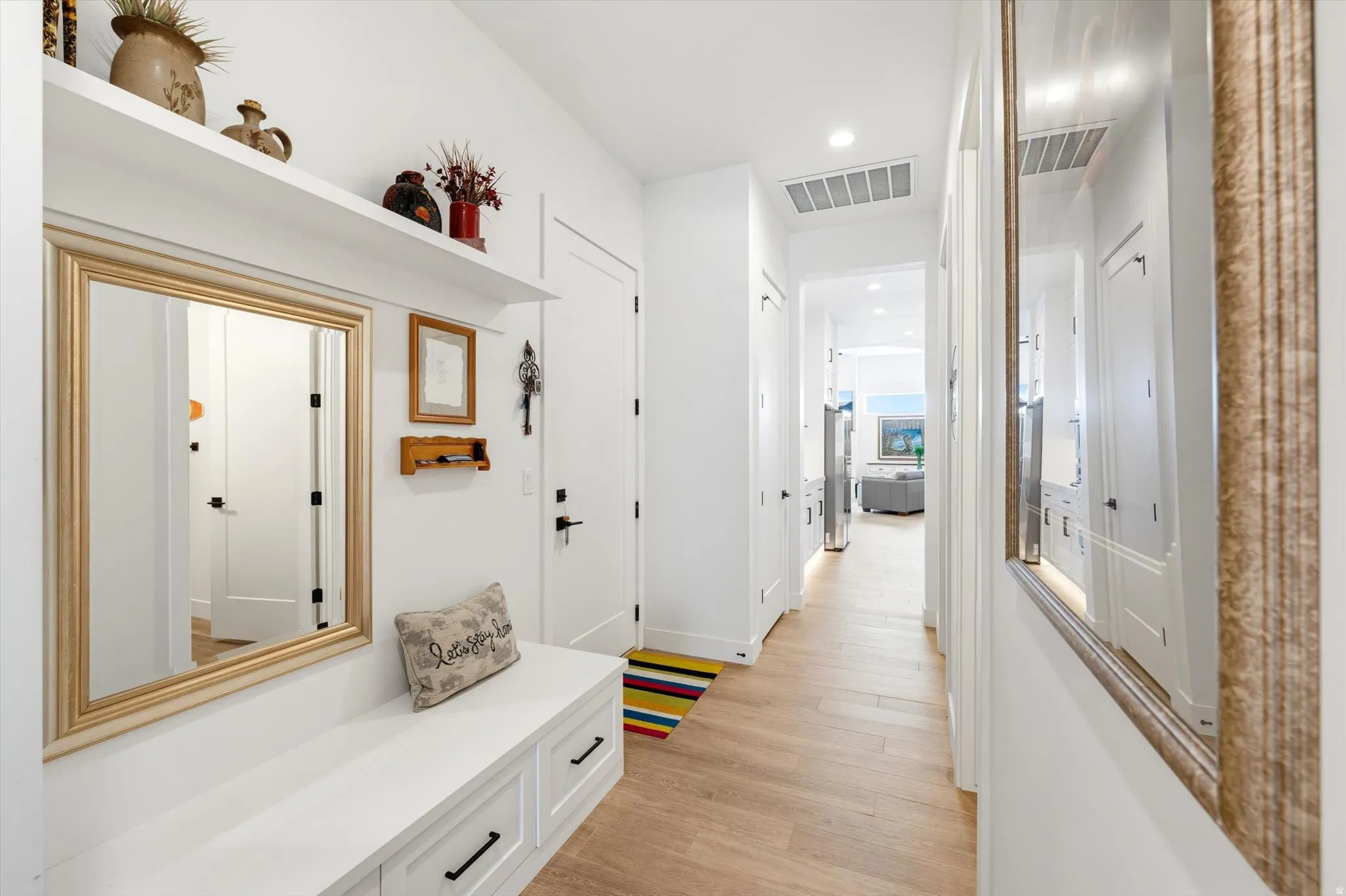 Hallway featuring wood-finish flooring, recessed lighting, and a built-in bench with storage drawers