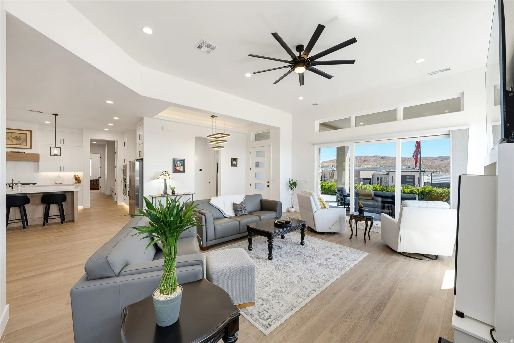 Recessed lighting throughout, wood-finish flooring, and a sliding glass door