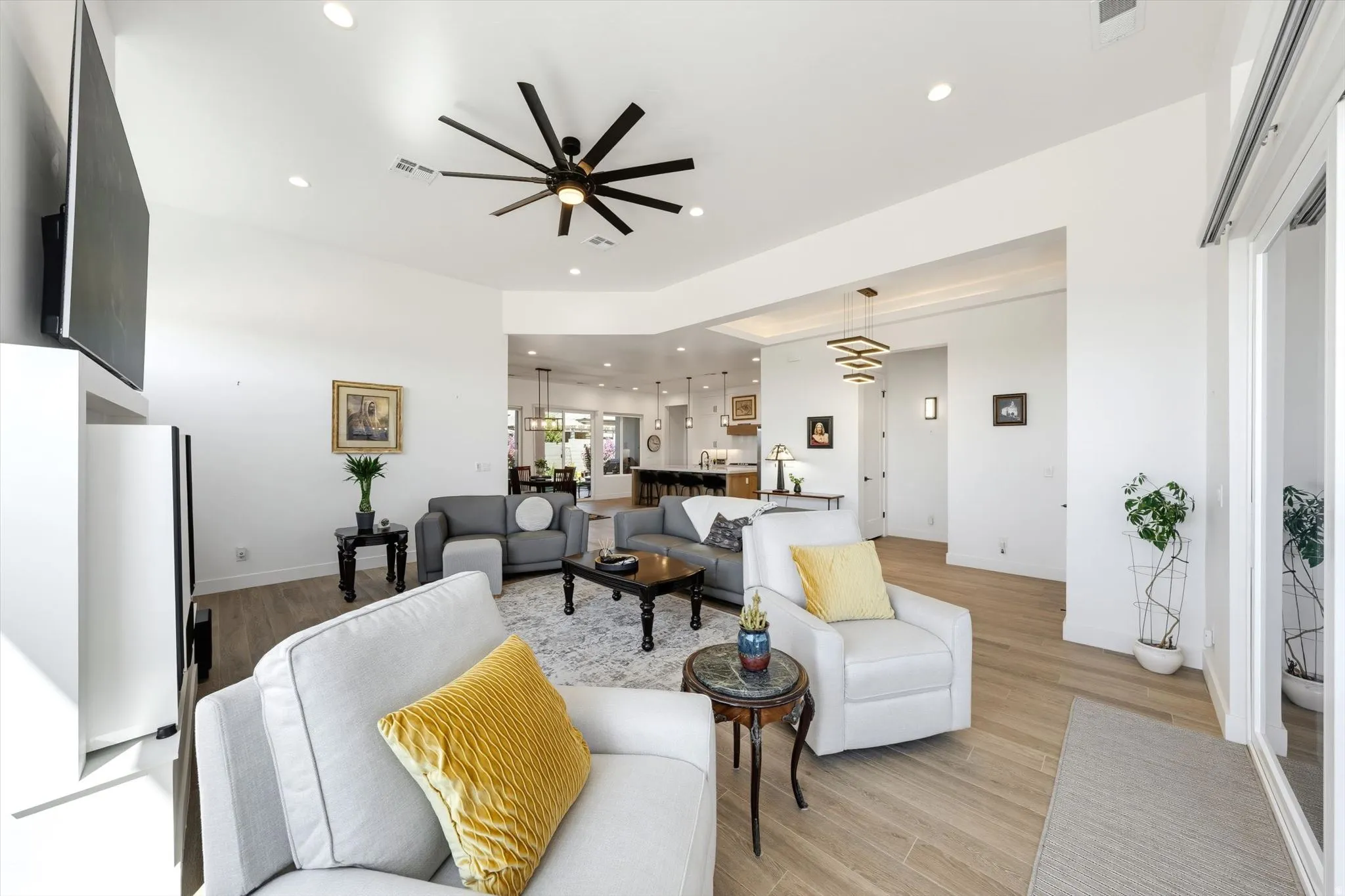 Recessed lighting, wood-finish flooring, and a contemporary ceiling fan with multiple blades