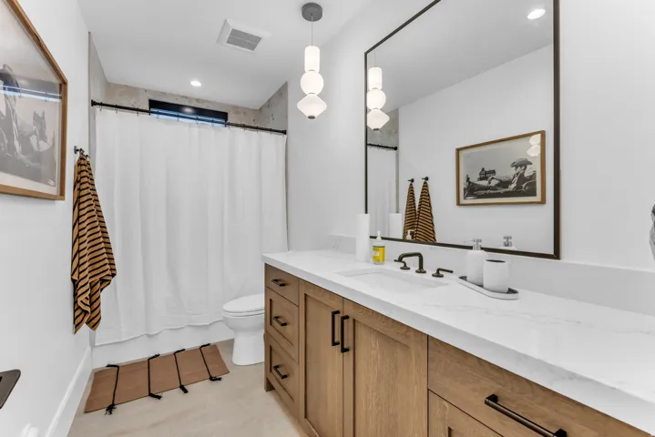 Floating wood-finish vanity with a white countertop and integrated sink
