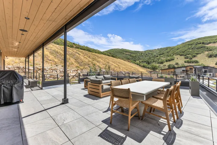 Expansive outdoor patio with wood-finish ceiling, recessed lighting, and tile flooring