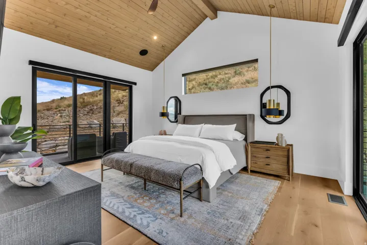 Vaulted wood-paneled ceiling, light wood-finish flooring, sliding glass doors, horizontal transom window, and built-in lighting fixtures