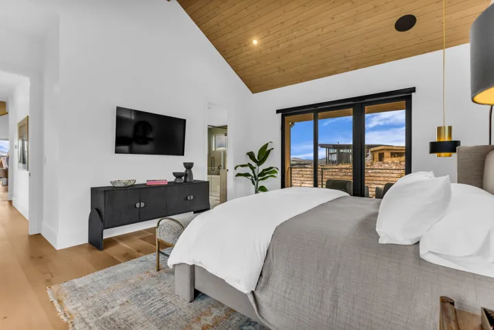 Vaulted wood-paneled ceiling, wood-finish flooring, sliding glass door, recessed lighting, and wall-mounted television