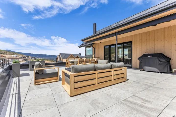 Expansive outdoor patio featuring large format tile flooring and metal railings