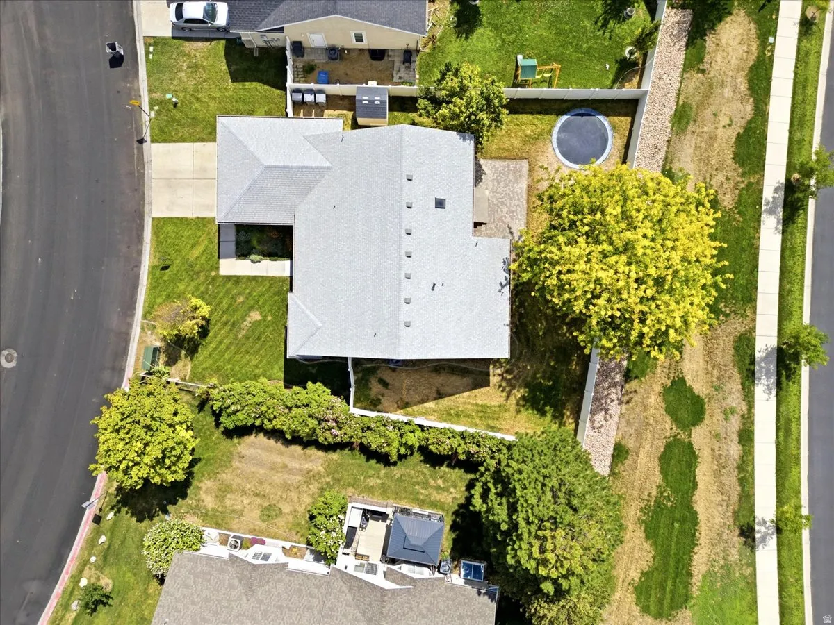 Single-story residence with a newer gray shingle roof, concrete driveway, and expansive green lawn