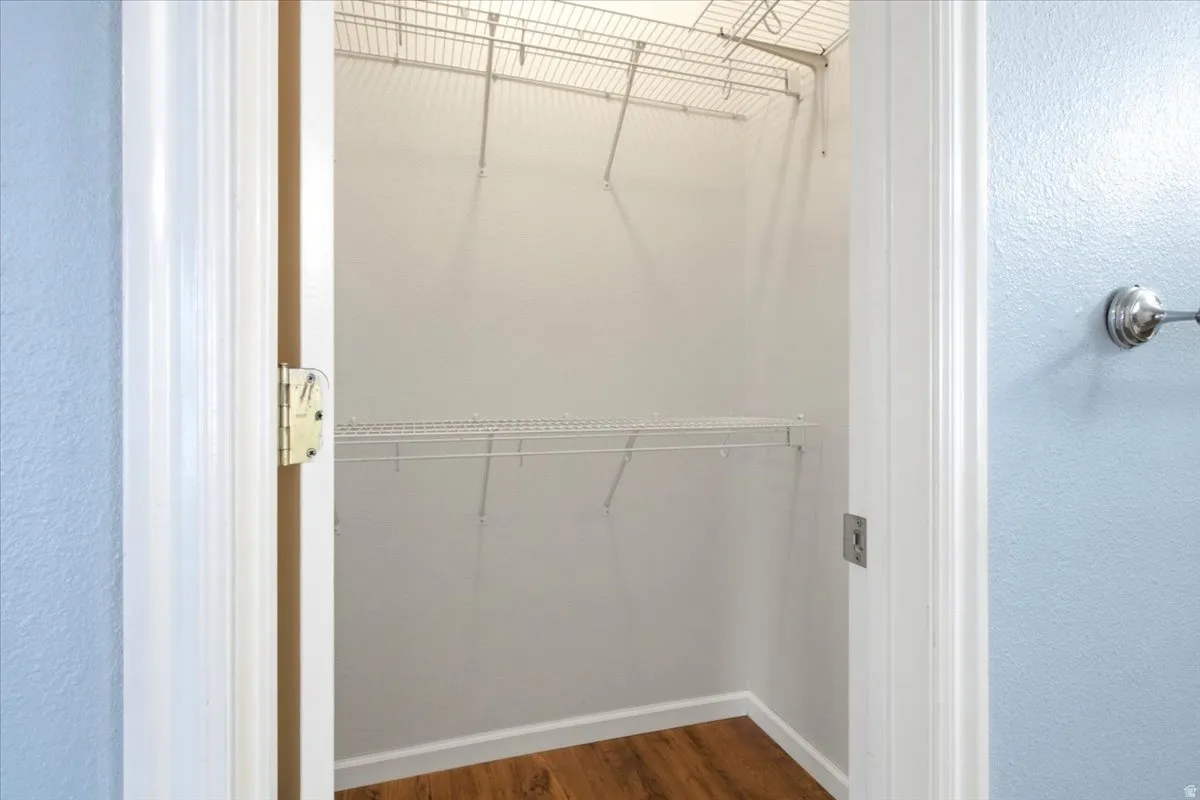 Built-in wire shelving system, wood-finish flooring, white baseboards, and white wall paint