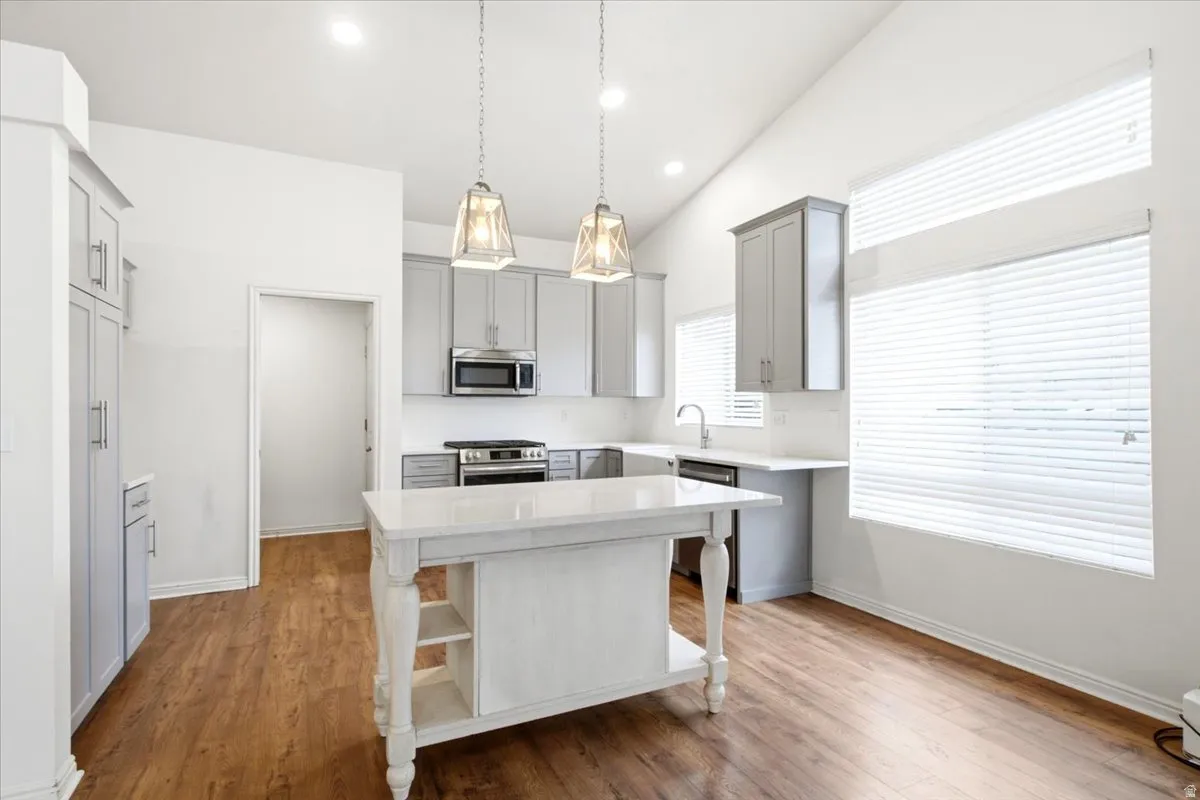 Kitchen featuring wood-finish flooring, vaulted ceilings, and updated cabinetry