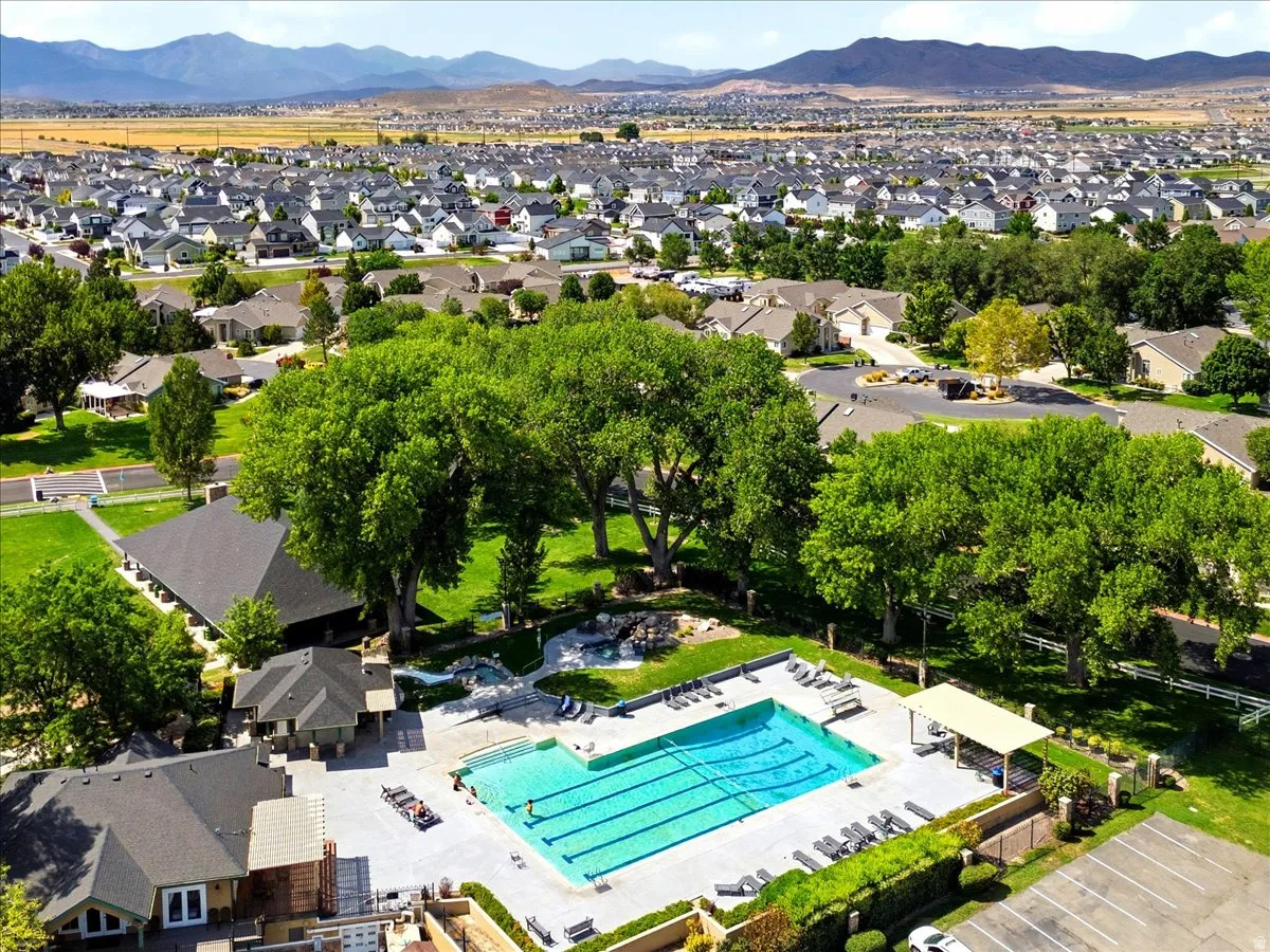 Expansive swimming pool with multiple lap lanes, surrounded by mature trees and mountain scenery
