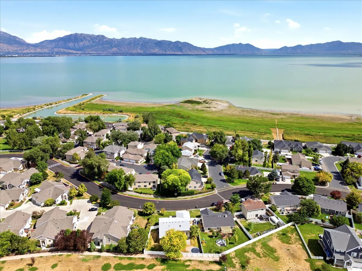Aerial perspective showcasing a residential neighborhood with a Utah Lake and mountain views
