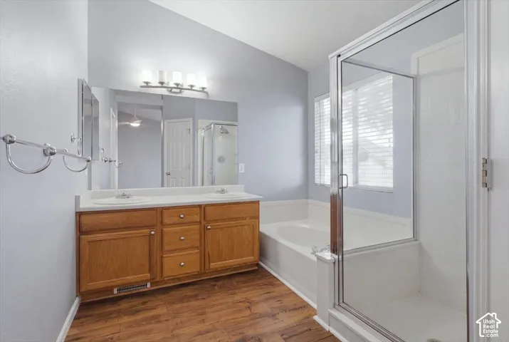 Primary Bathroom. Dual Basin Vanity with Wood Cabinetry, Separate Shower, and Large Bathtub