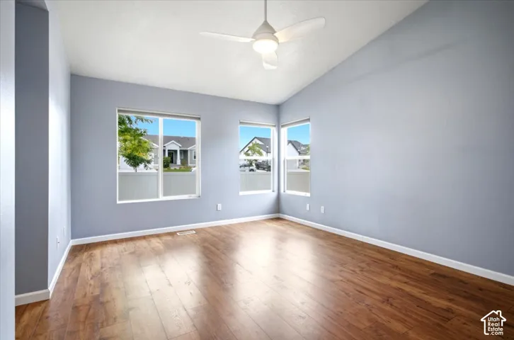Primary Bedroom with Vaulted Ceilings, Updated  Ceiling Fan, and Windows with View of Backyard.