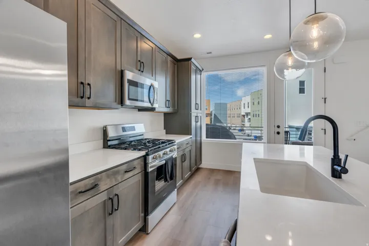 Kitchen featuring quartz countertops, gas range and generous cabinet space.