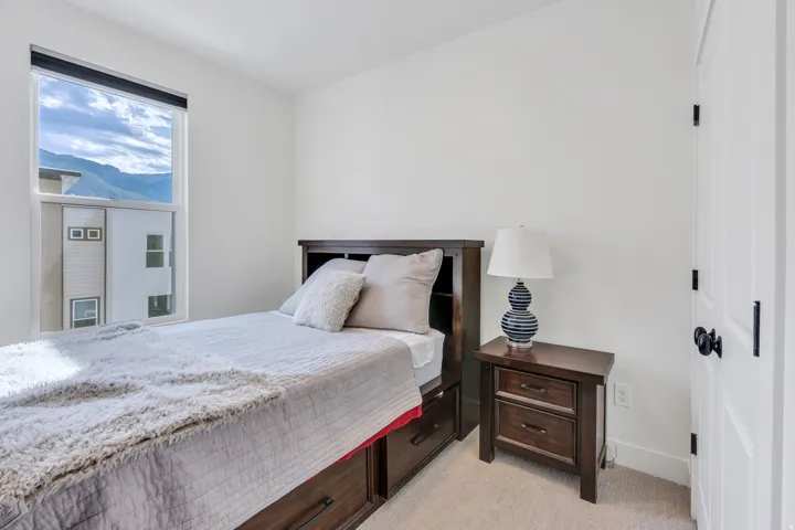 Secondary bedroom with natural light and mountain views.