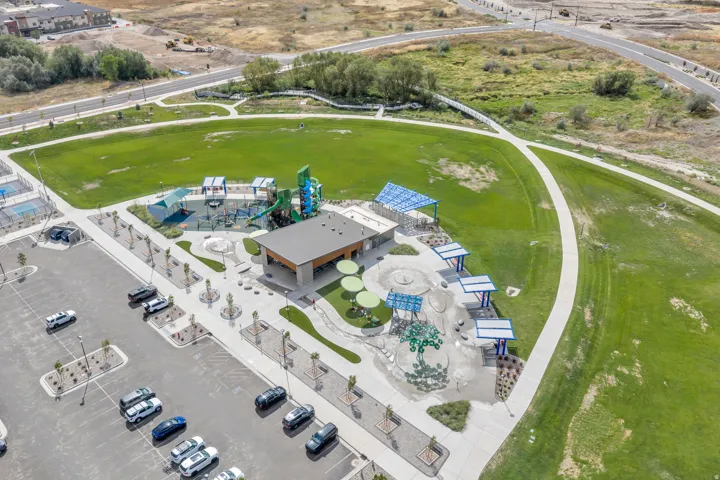 Nearby city park featuring playground, splash area and expansive green space.