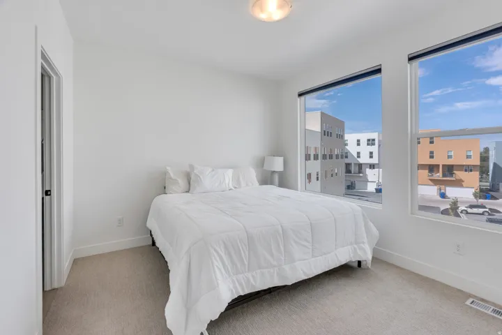 Spacious primary bedroom with large windows and natural light.