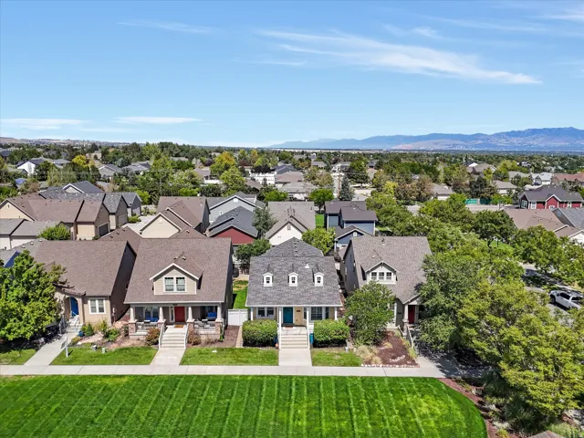 Gabled roofline, dormer windows, covered front porch, and established landscaping