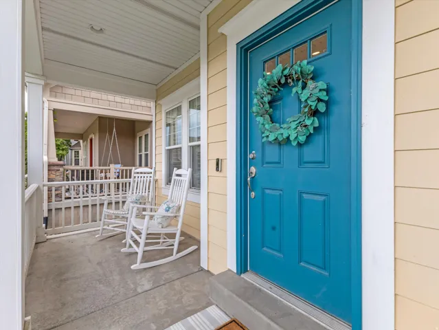Covered front porch with concrete flooring and white railing