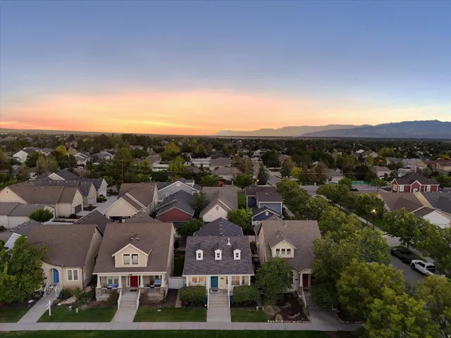 Residential street lined with mature trees, offering a neighborhood setting with distant mountains