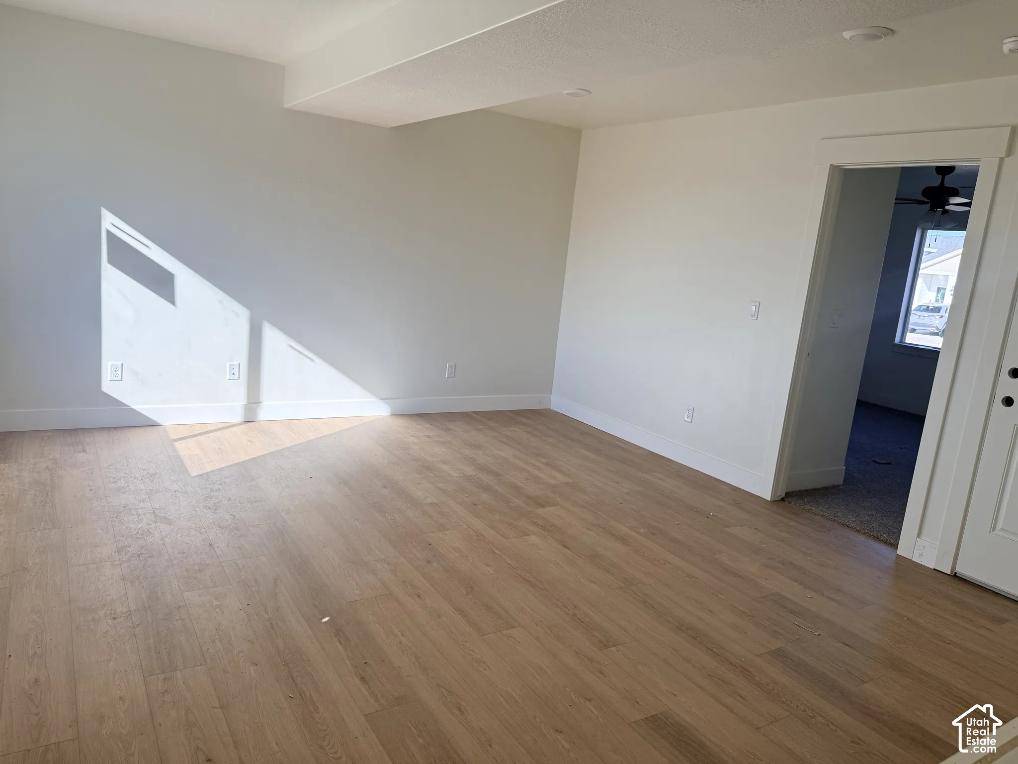 Neutral-toned walls paired with wood-finish flooring and recessed lighting