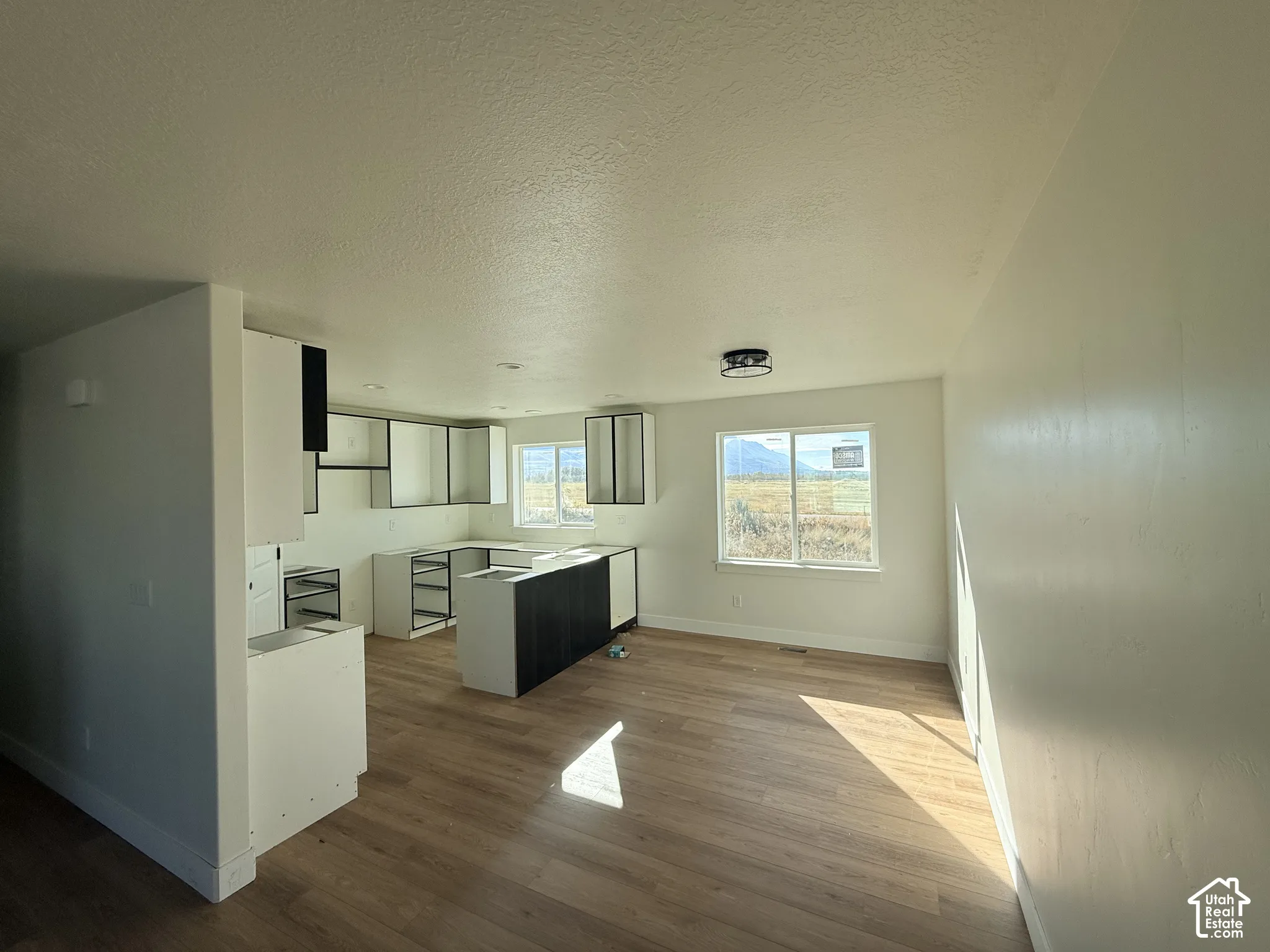 Kitchen featuring two-tone cabinetry, wood-finish flooring, recessed lighting, and large windows with mountain scenery
