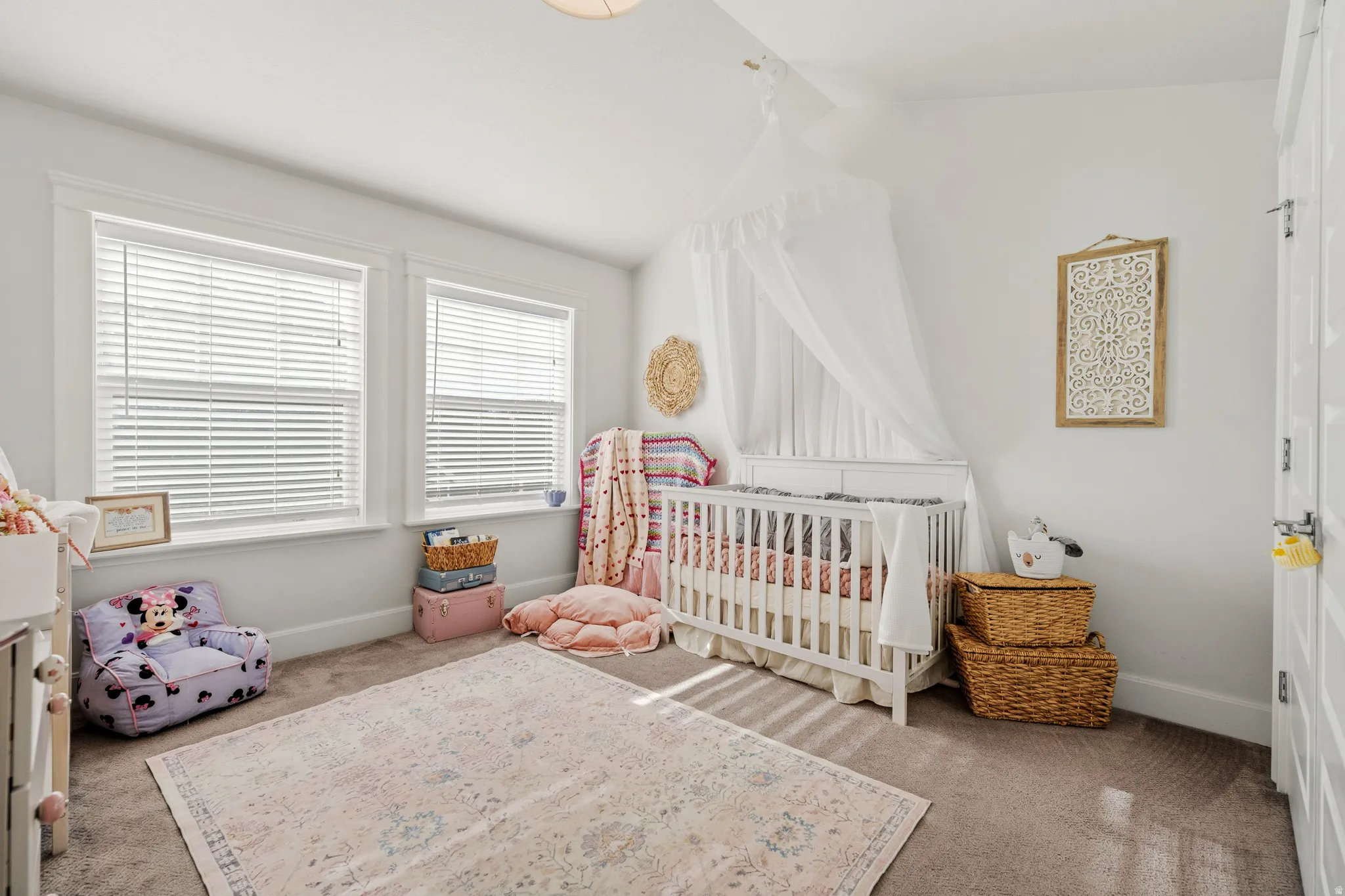Two windows with blinds, white trim, and a white interior door