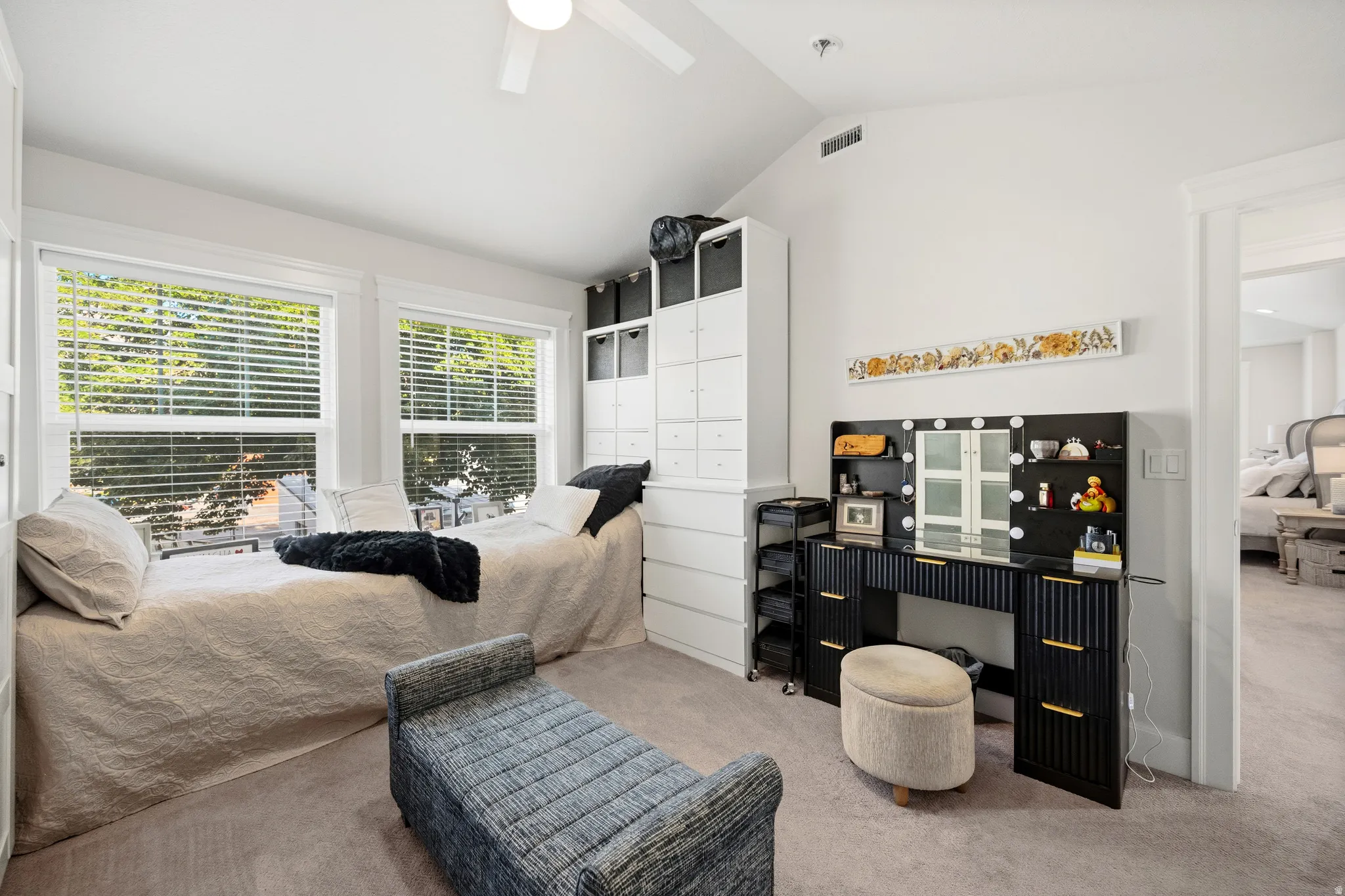 Two large windows, a sloped ceiling, and carpeted flooring
